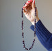holding garnet necklace