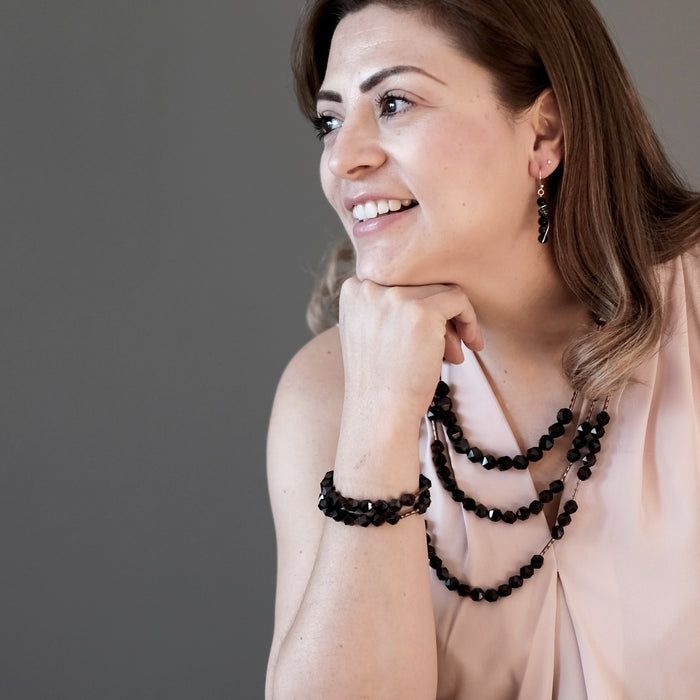 female model wearing three different length garnet necklaces 