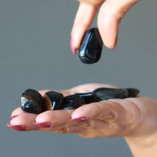 hand holding Hawks Eye Tumbled Stones