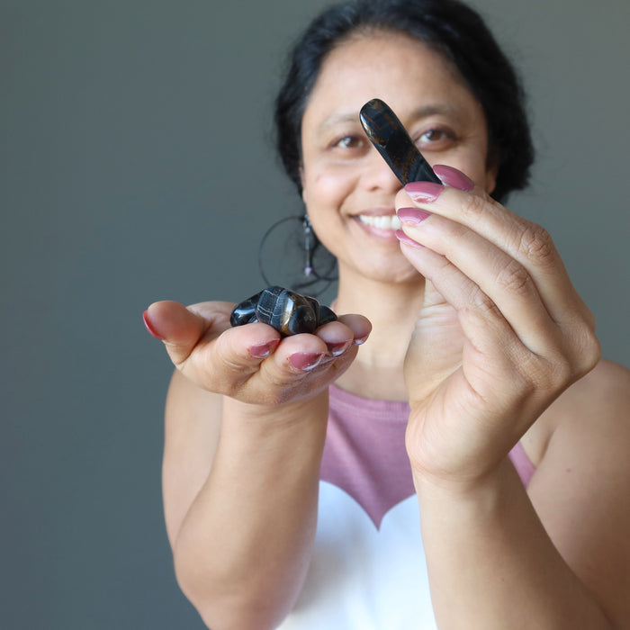 sheila of satin crystals holding Hawks Eye Tumbled Stones on both hands