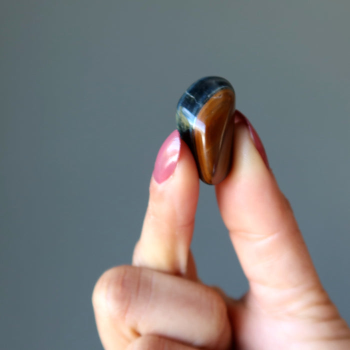 holding one Hawks Eye Tumbled Stone