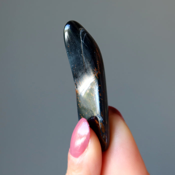 holding one Hawks Eye Tumbled Stone