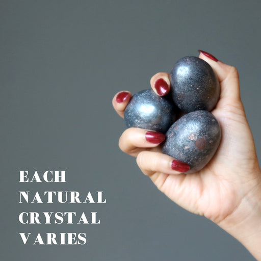 hand holding three hematite eggs showing each natural crystal varies