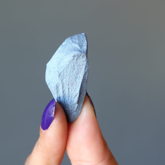 hand holding raw hematite stone