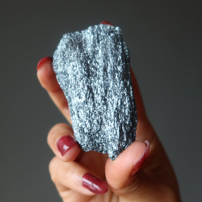 raw specular hematite stone in hand