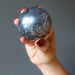 hand holding hematite sphere