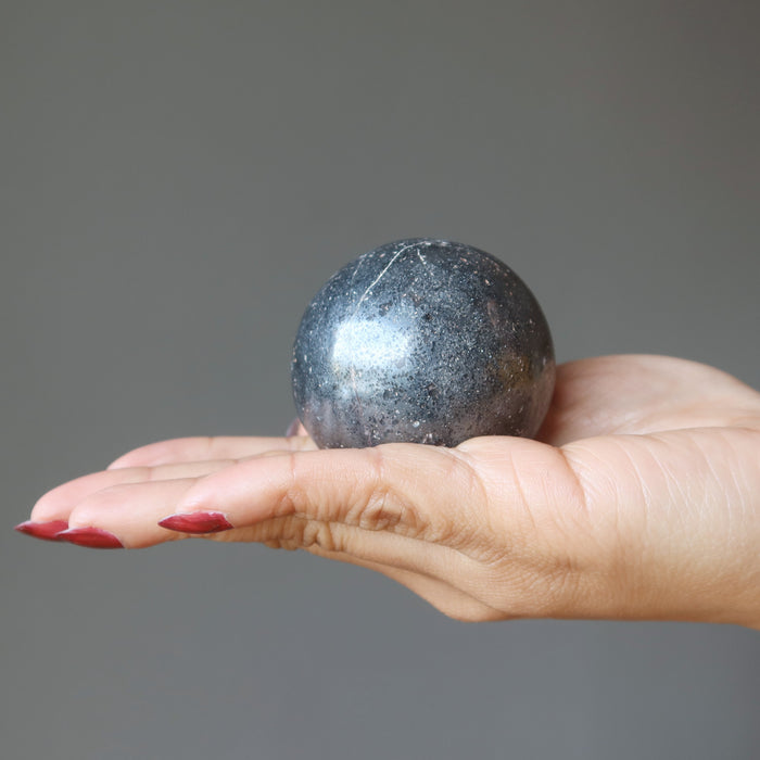hand holding hematite sphere