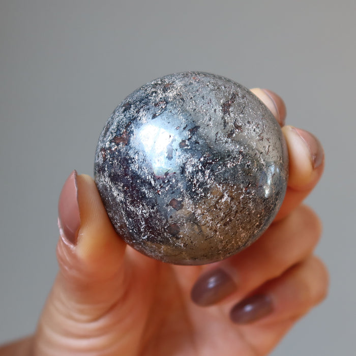 hand holding hematite sphere