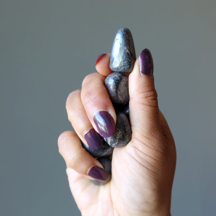 hand holding Hematite Tumbled Stones