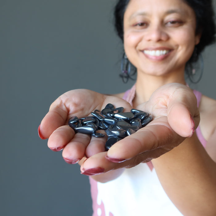 sheila of satin crystals holding Hematite Tumbled Stones on palm