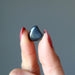 finger tips holding Hematite Tumbled Stone