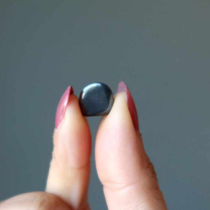 finger tips holding Hematite Tumbled Stone