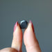 finger tips holding Hematite Tumbled Stone