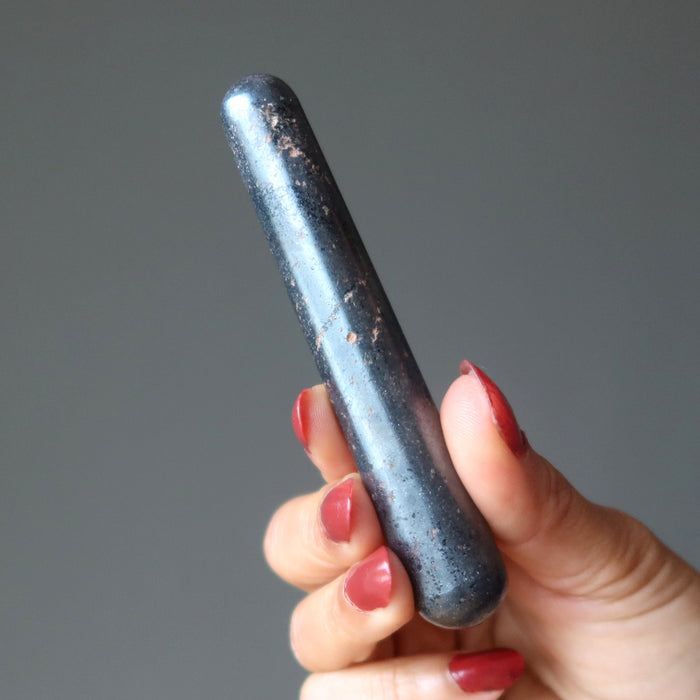 hand holding a hematite massage wand