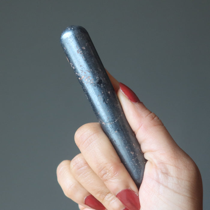 hand holding a hematite massage wand