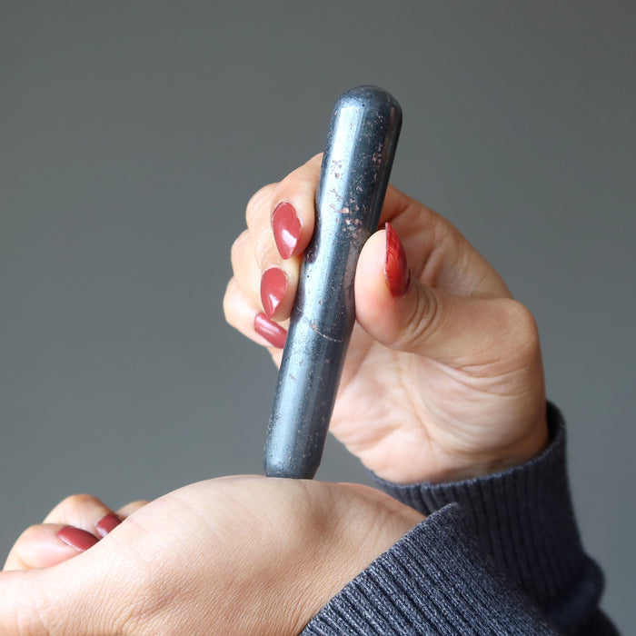 hand holding a hematite massage wand