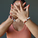 model wearing two howlite redjasper bracelets on right wrist and one on left wrist 