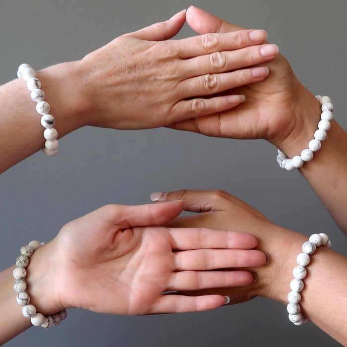 four hands all wearing howlite stretch bracelets