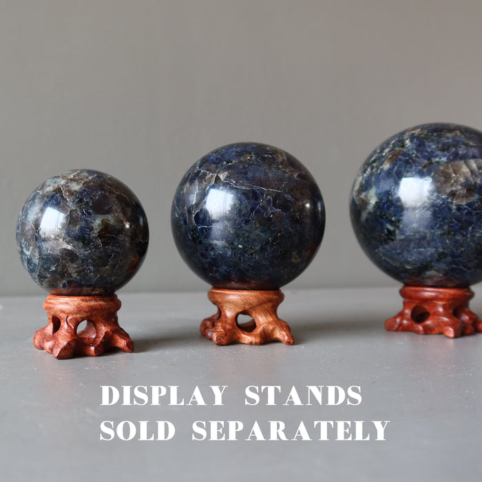 three iolite spheres on fancy wood stands
