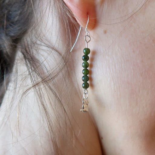 woman modeling jade owl earrings