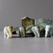 four jade elephants in front of raw jade slabs