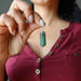 woman holding jade faceted point pendant at chest