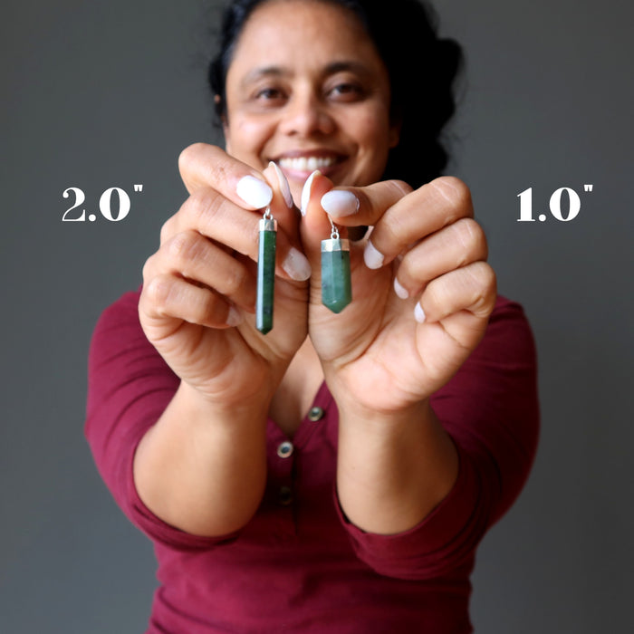 woman holding two jade faceted point pendant at different lengths