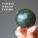 hand holding dark green nephrite jade sphere