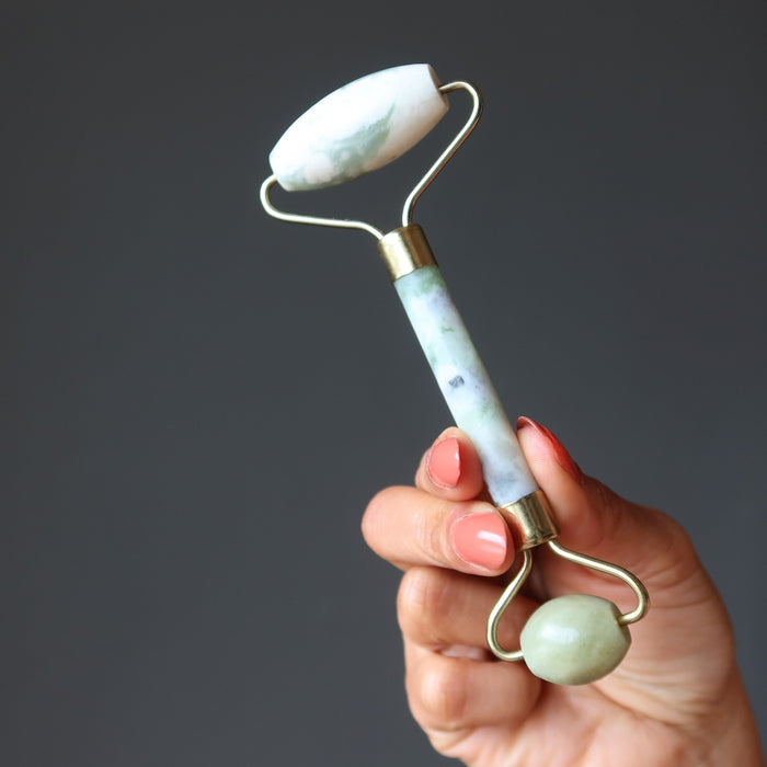 hand holding a green jade facial roller
