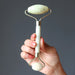 hand holding a green jade facial roller