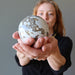 woman gazing at ocean jasper sphere