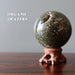 spotted ocean jasper sphere on wood stand