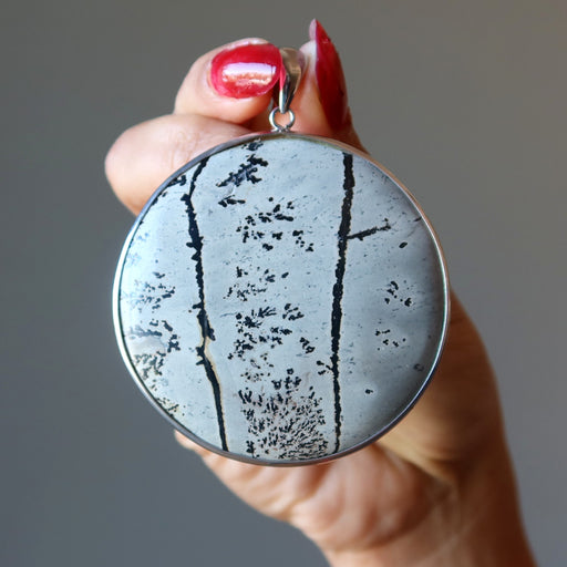 hand holding dendritic jasper pendant