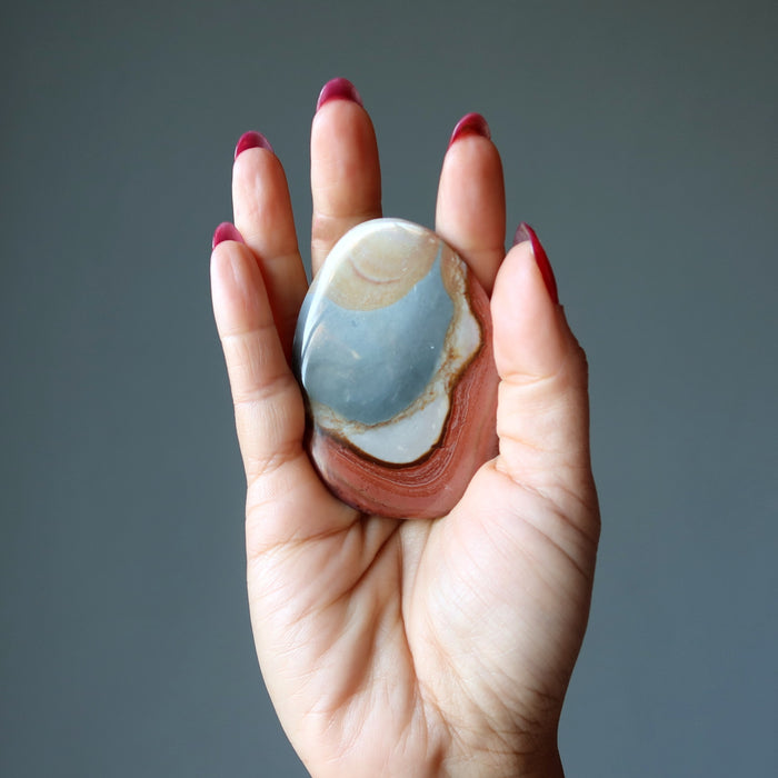 hand holding polychrome jasper crystal in palm