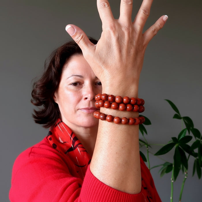 woman wearing three red jasper bracelets