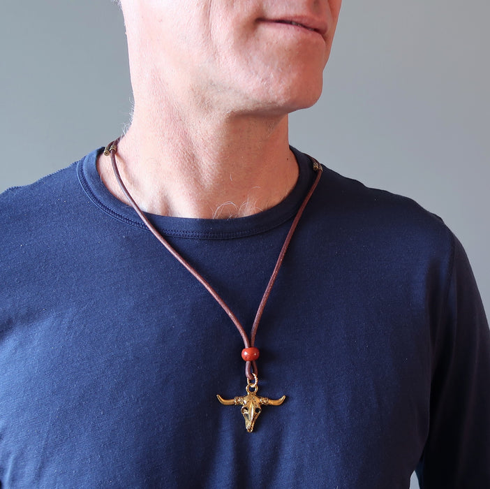 man wearing gold jasper bull skull necklace