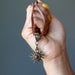 hand holding red jasper sun necklace