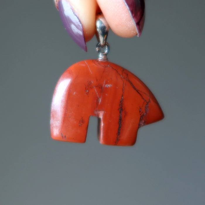 hand holding red jasper bear pendant