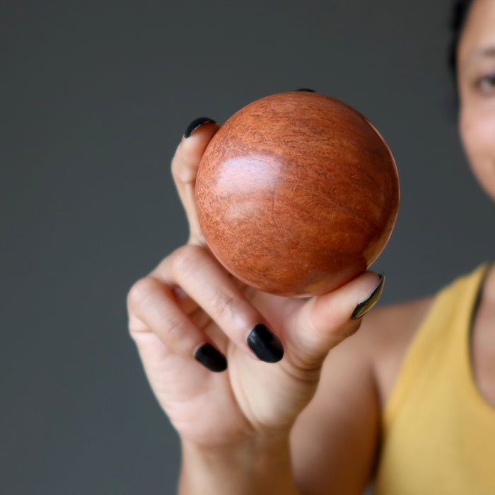 sheila of satin crystals holding a red jasper spheres