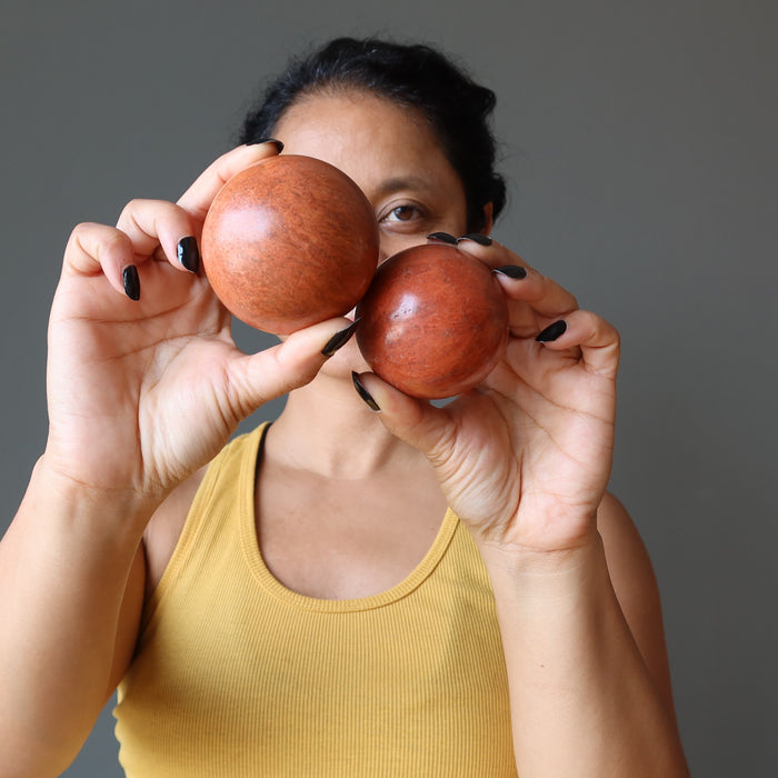 sheila of satin crystals holding 2 red jasper spheres