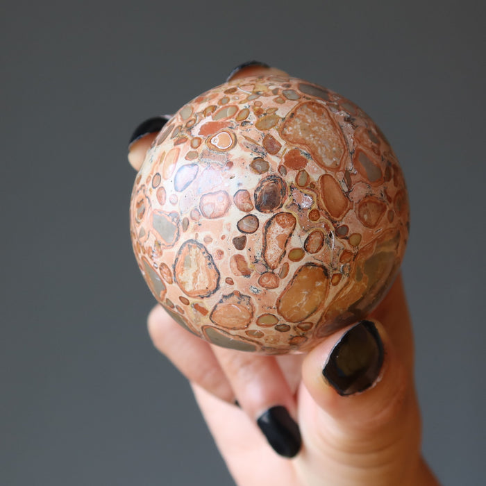 hand holding safari jasper sphere