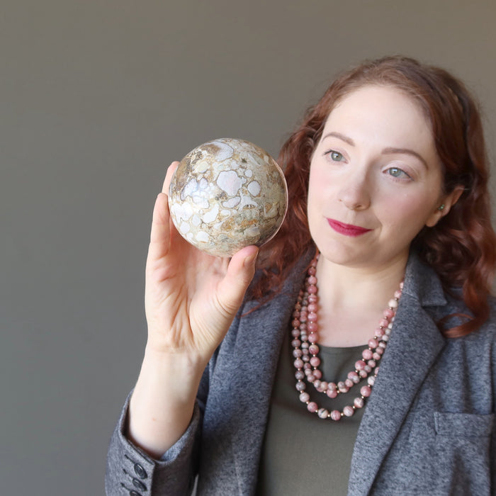 female model holding snake jasper sphere