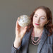 female model holding snake jasper sphere
