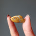 hand holding yellow jasper tumbled stone