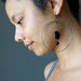 woman wearing jet stone hoop earrings