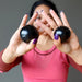 woman holding two jet stone spheres