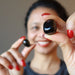 female holding out a jet tumbled stones