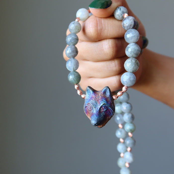 hand holding labradorite wolf necklace