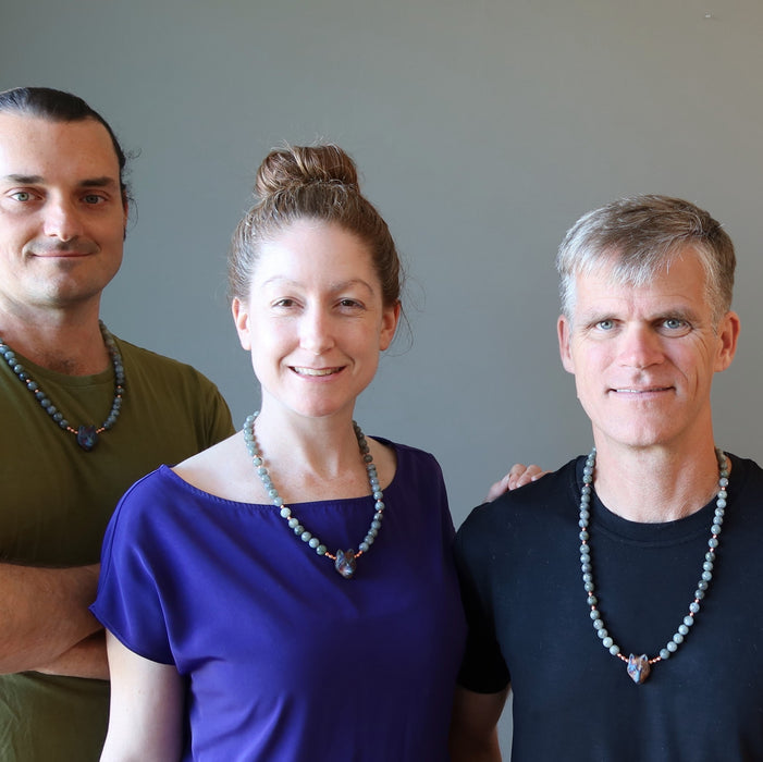 two males and a female wearing labradorite wolf head necklaces