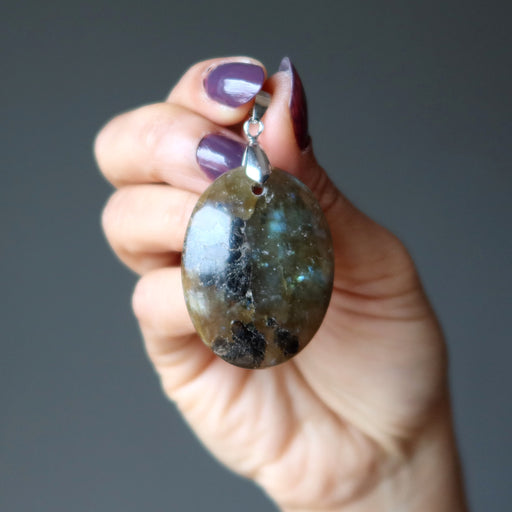 hand holding oval labradorite pendant